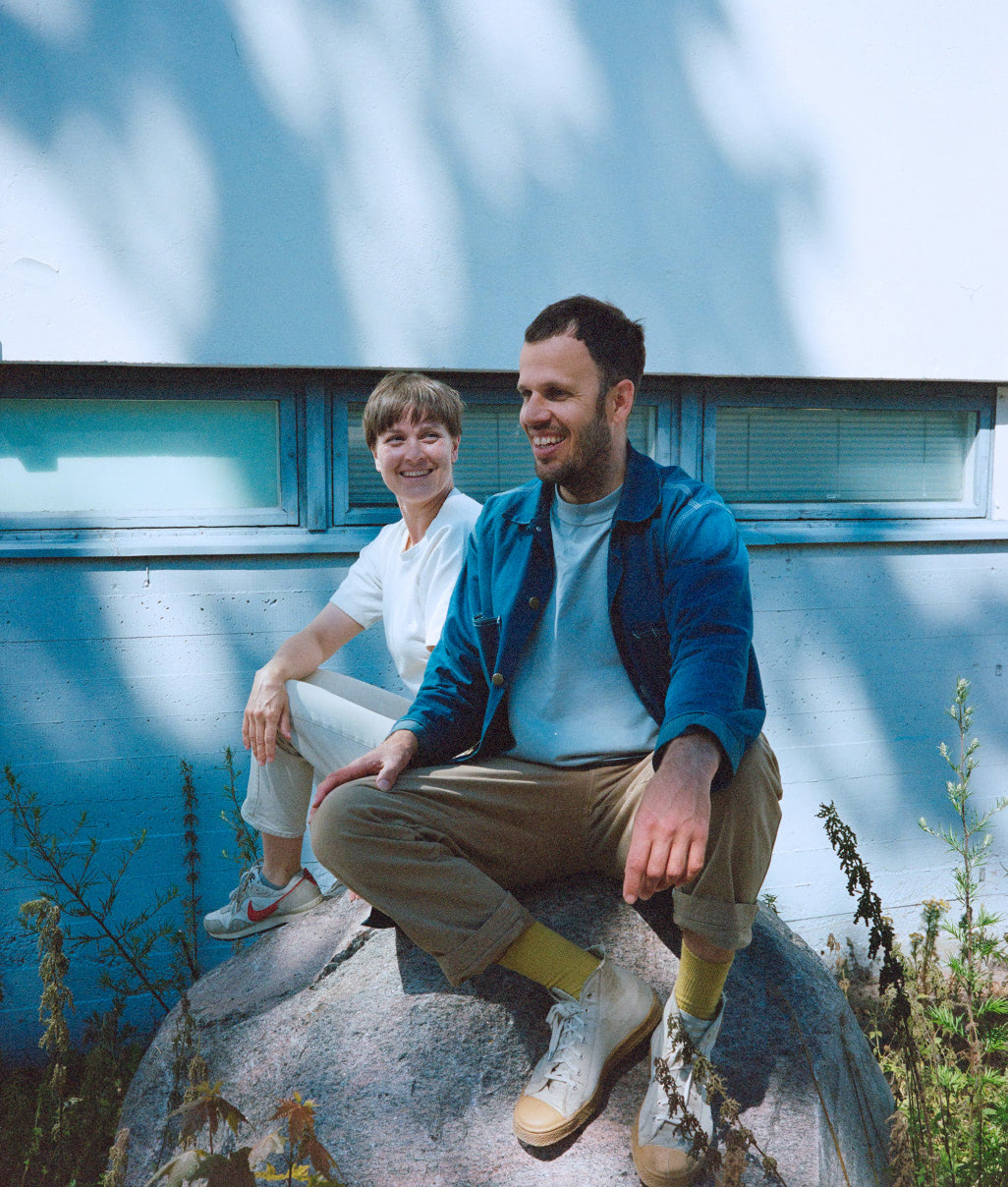 Salla Luhtasela and Wesley Walters sitting outside on a big rock